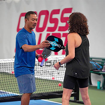Photo of a woman getting pickleball instruction